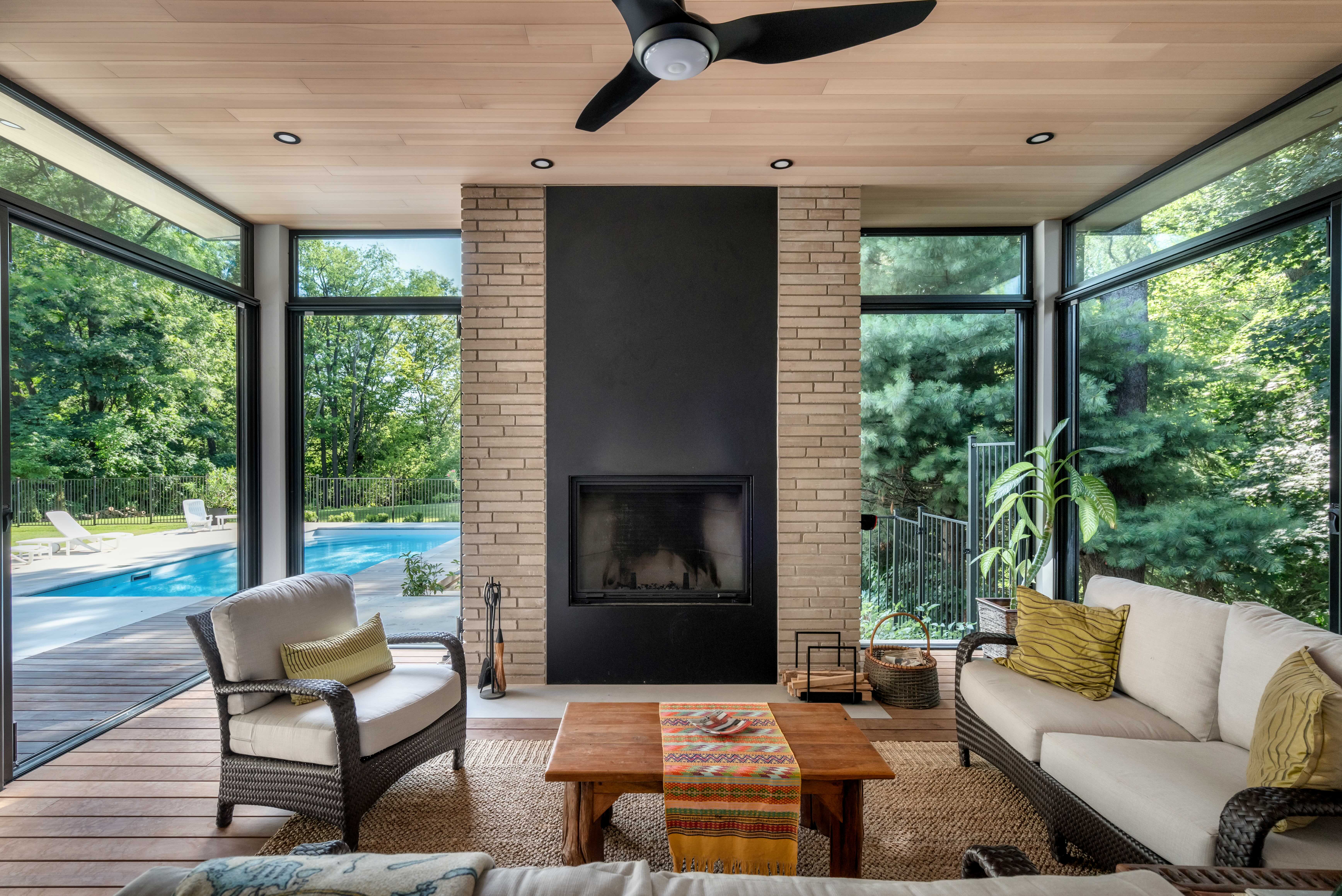 Poolside lounge framed by tall glazing and brick columns